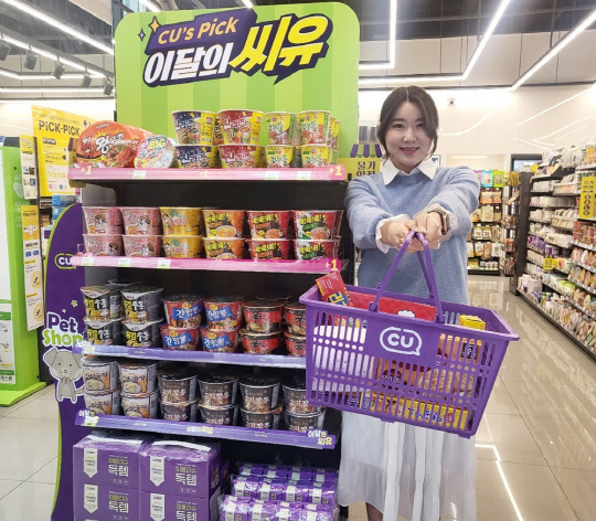 모델이 CU의 '득템' 시리즈 앞에서 포즈를 취하고 있다. CU 제공